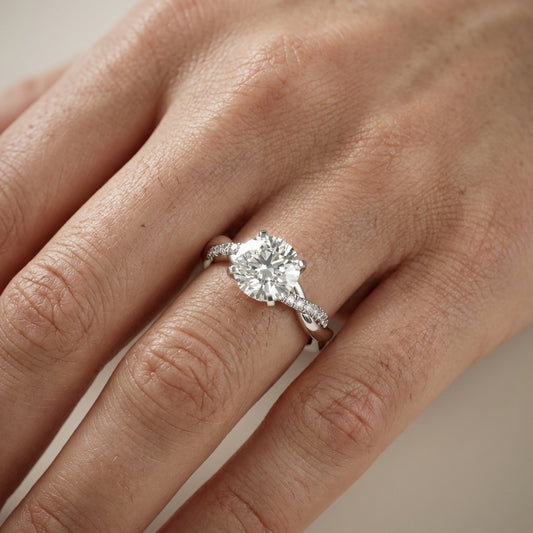 Round cut lab grown diamond twisted side stone engagement ring in platinum