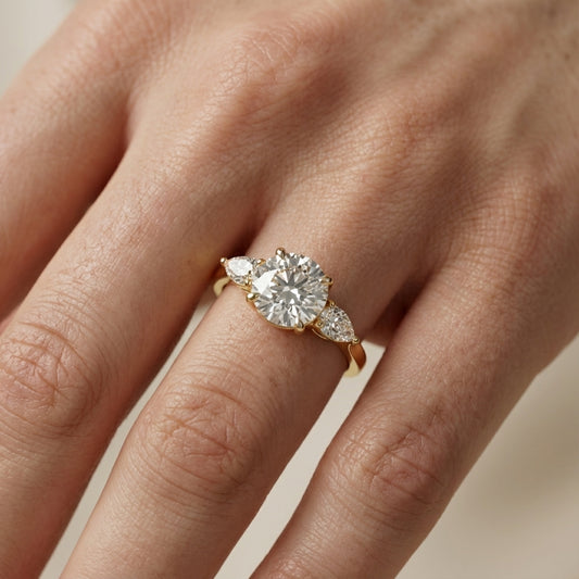 Round cut lab grown diamond three stone engagement ring in yellow gold setting