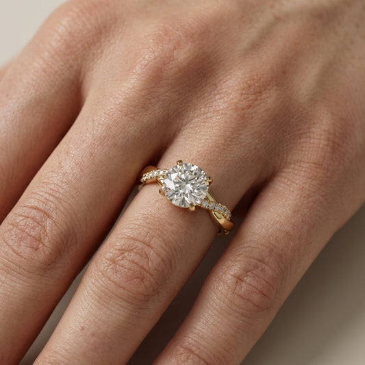 Round cut lab grown diamond twisted side stone engagement ring in yellow gold