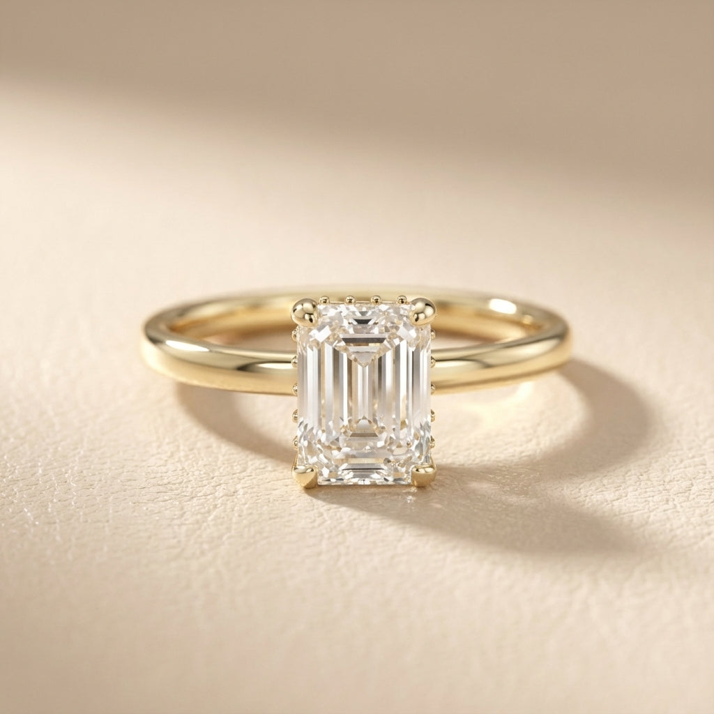 Emerald Cut Lab Grown Diamond Solitaire Engagement Ring in Yellow Gold on a light background