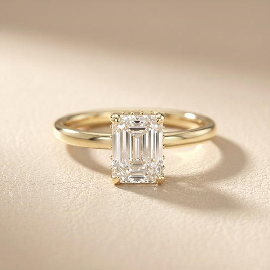 Emerald Cut Lab Grown Diamond Solitaire Engagement Ring in Yellow Gold on a light background