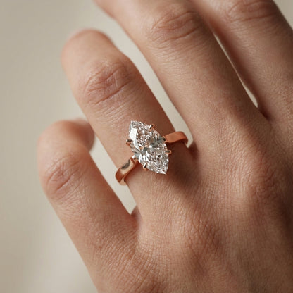 Marquise cut lab grown diamond solitaire engagement ring in warm rose gold floral setting.