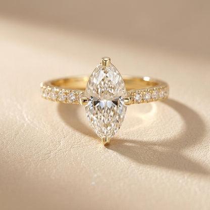 Traditional yellow gold engagement ring with a marquise cut lab grown diamond and side stone detailing.