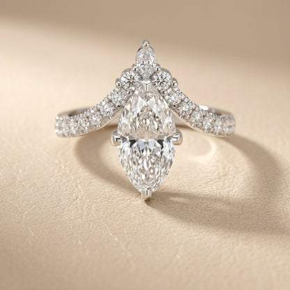 Marquise cut lab grown diamond engagement ring with side stones in a polished silver setting.