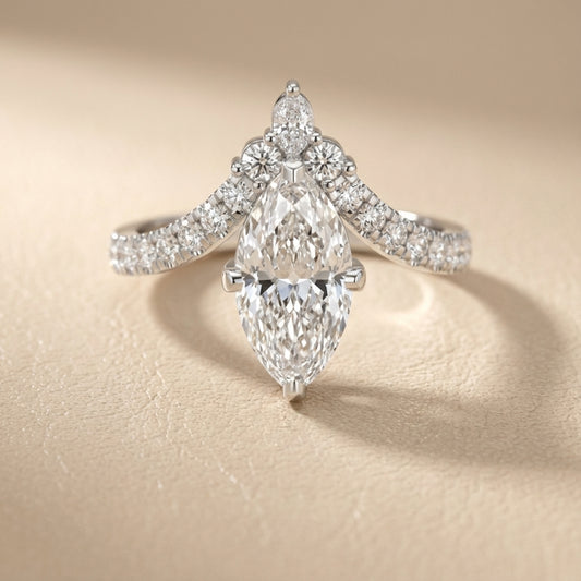 Platinum engagement ring showcasing a marquise cut lab grown diamond with pave side stones.