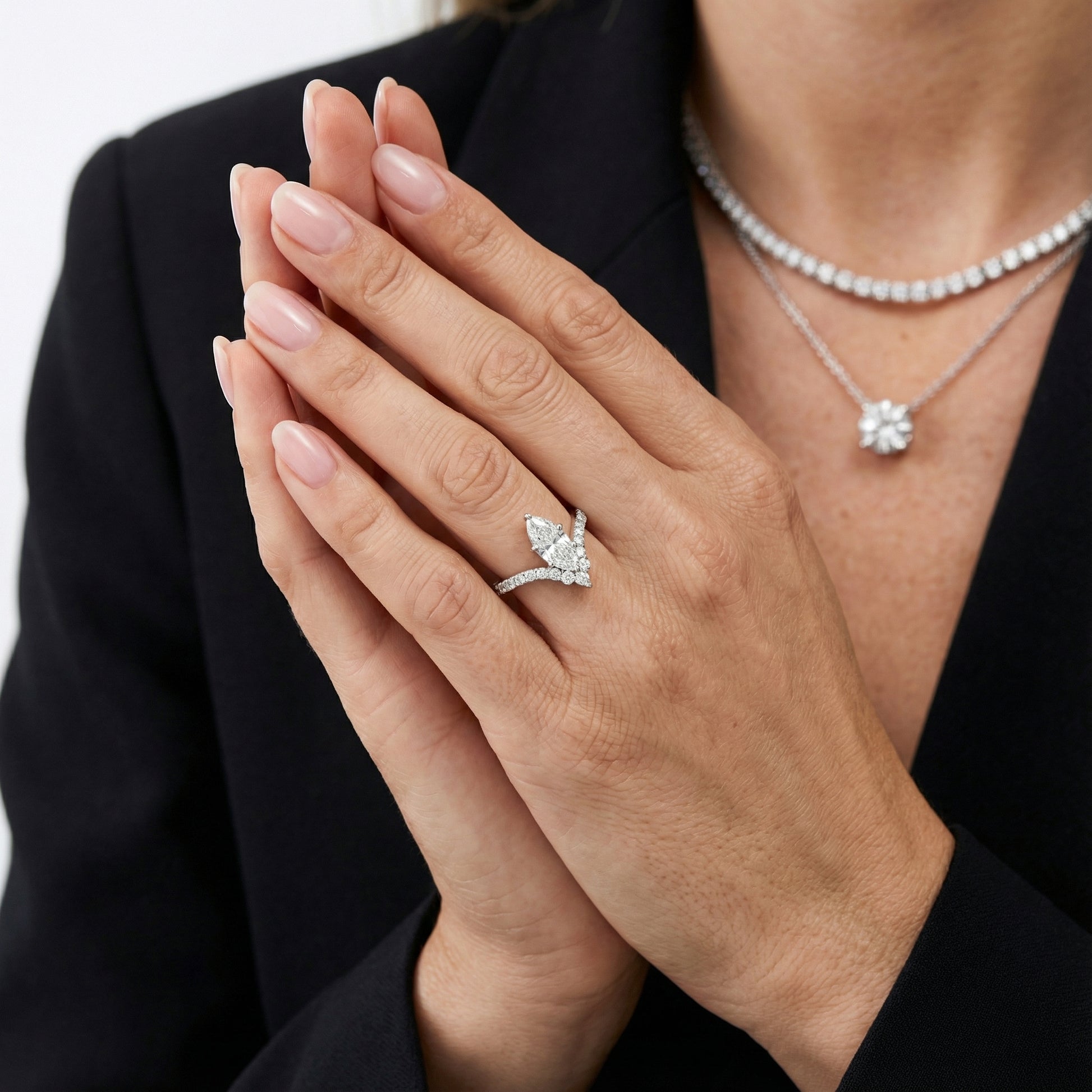 Platinum engagement ring showcasing a marquise cut lab grown diamond with pave side stones.