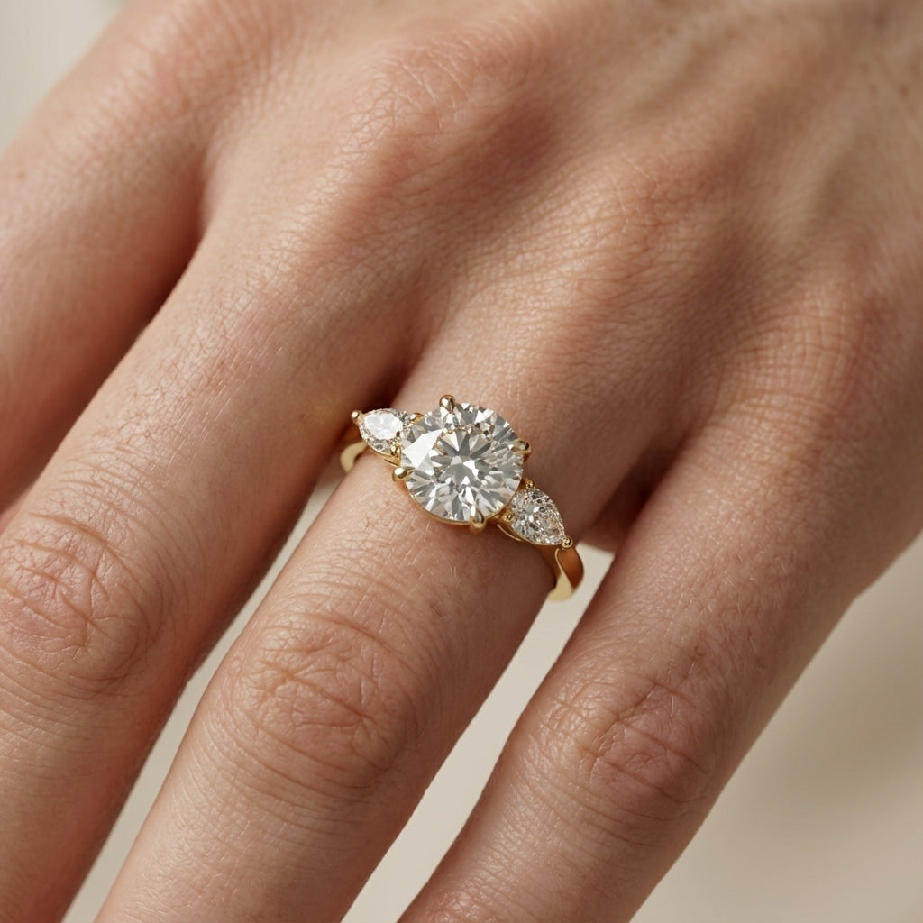 Round cut lab grown diamond three stone engagement ring in yellow gold setting