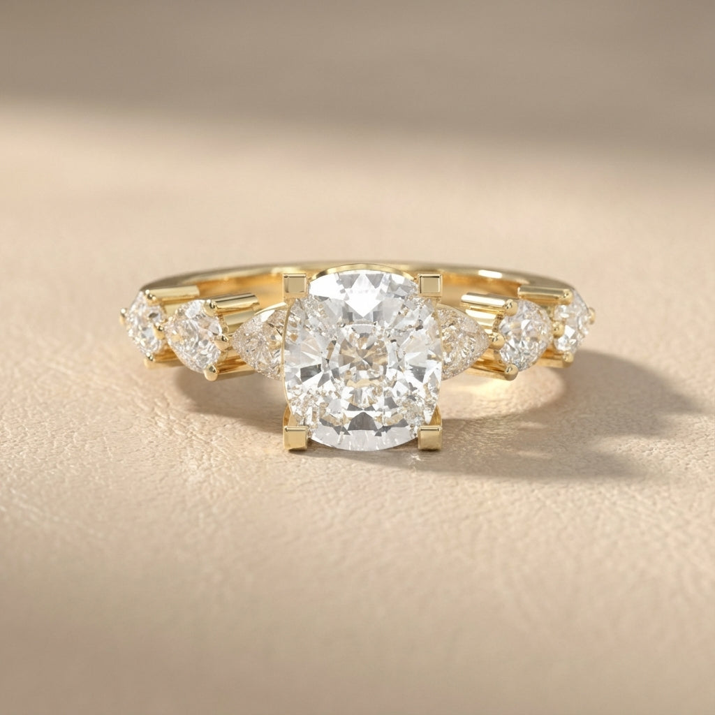 Cushion cut lab grown diamond engagement ring with marquise and pear side stones set in rich yellow gold.