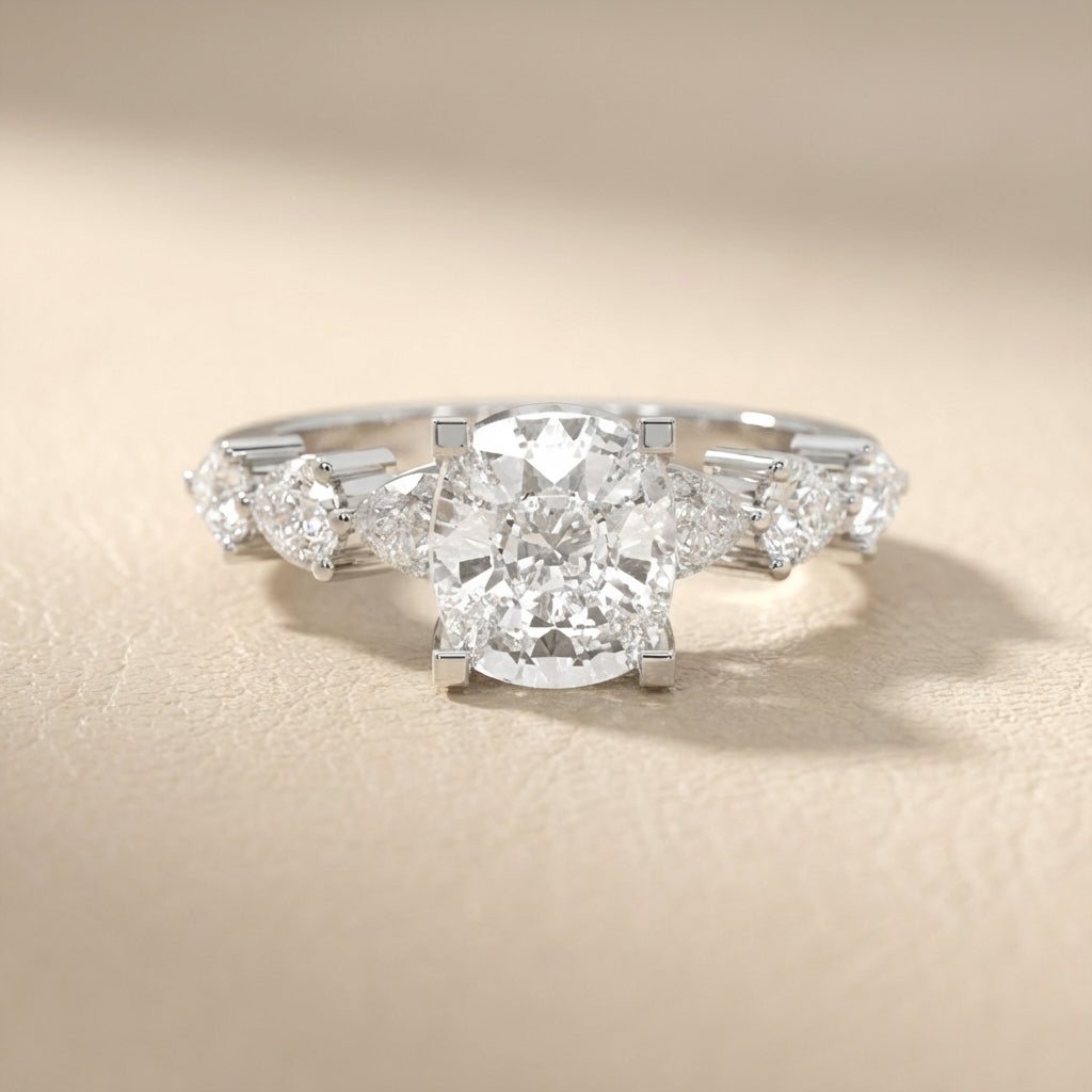 Cushion cut lab grown diamond engagement ring with marquise and pear side stones set in gleaming white gold.