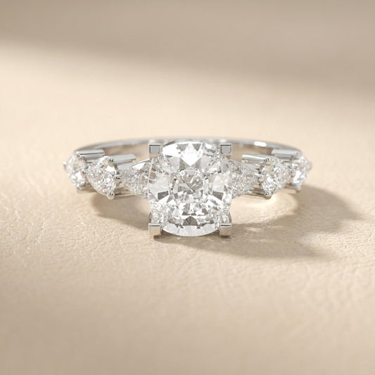 Cushion cut lab grown diamond engagement ring with marquise and pear side stones set in gleaming white gold.