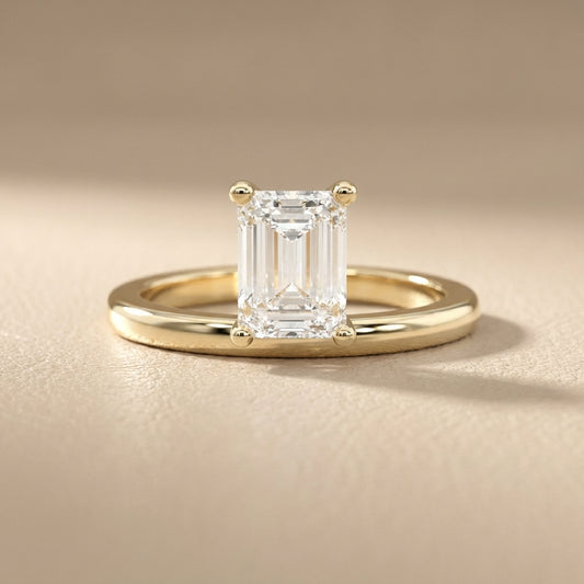 Emerald Cut Lab Grown Diamond Solitaire Engagement Ring in traditional Yellow Gold setting.