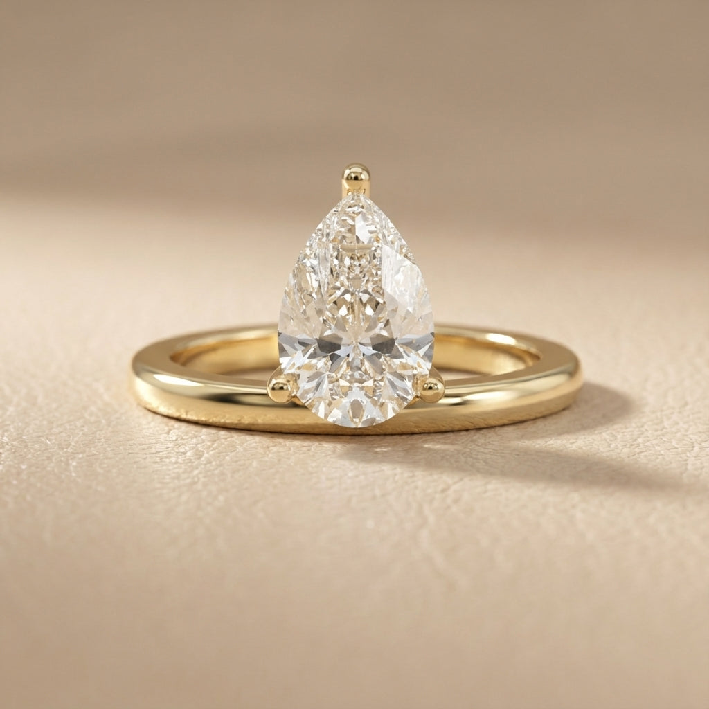 Pear Cut Lab Grown Diamond Solitaire Engagement Ring in Yellow Gold showing traditional band and modern setting.