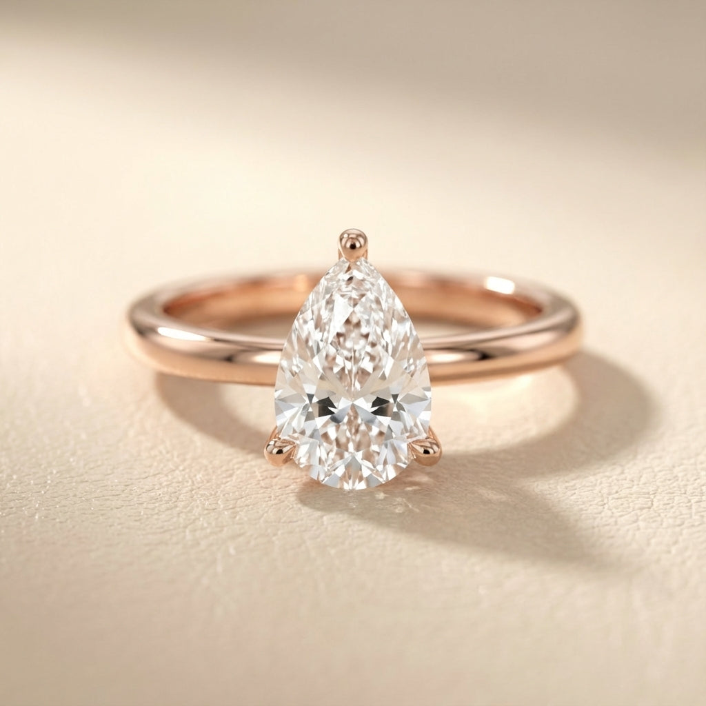 Pear Cut Lab Grown Diamond Solitaire Engagement Ring in Rose Gold with claw prongs and chevron basket.