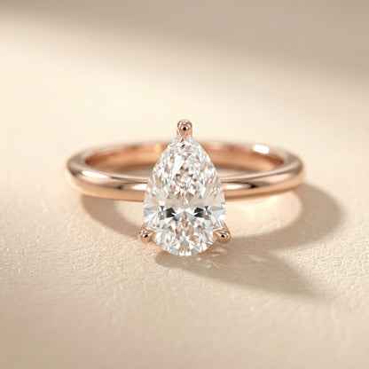 Pear Cut Lab Grown Diamond Solitaire Engagement Ring in Rose Gold with claw prongs and chevron basket.