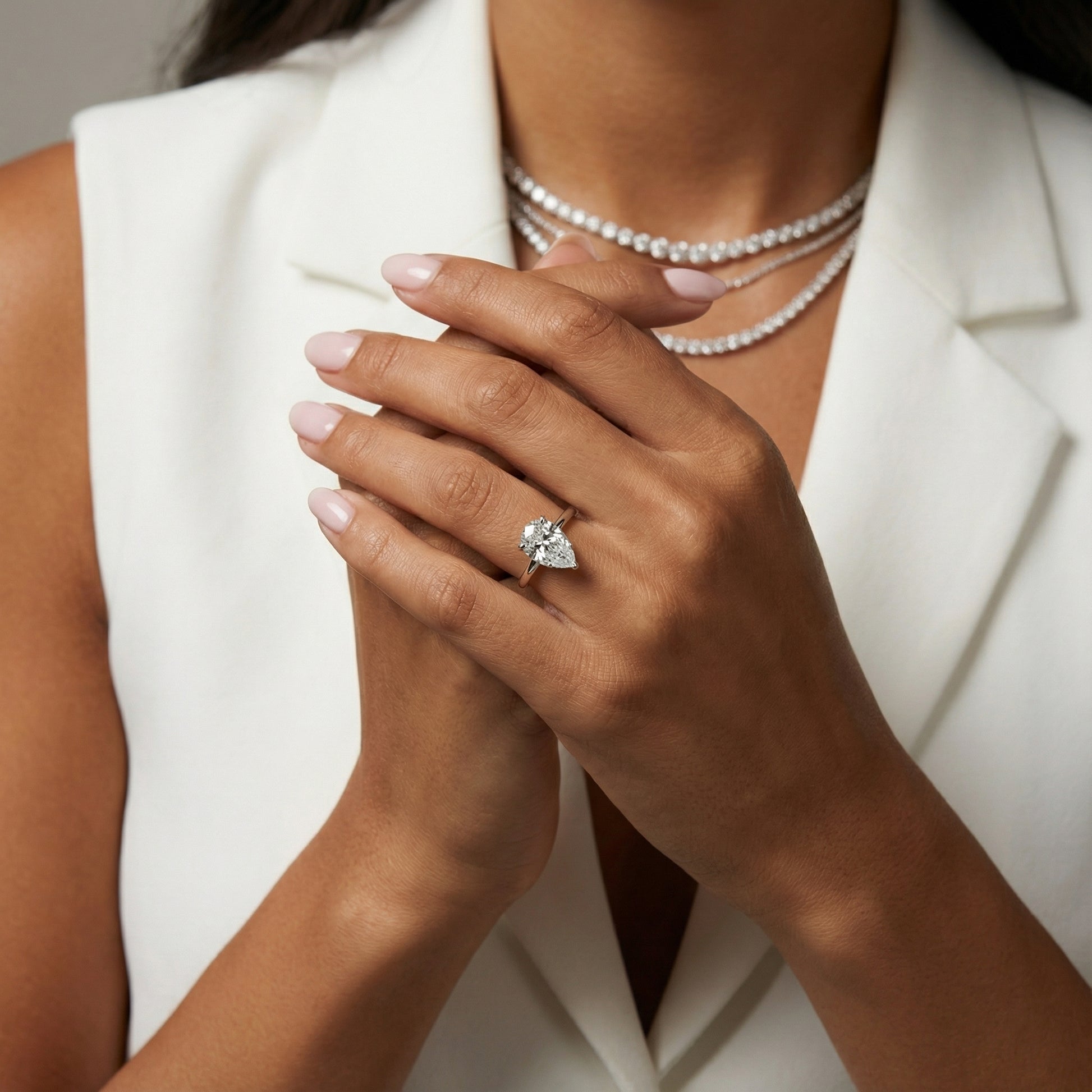 Pear Cut Lab Grown Diamond Solitaire Engagement Ring in Platinum with subtle chevron gallery detail.