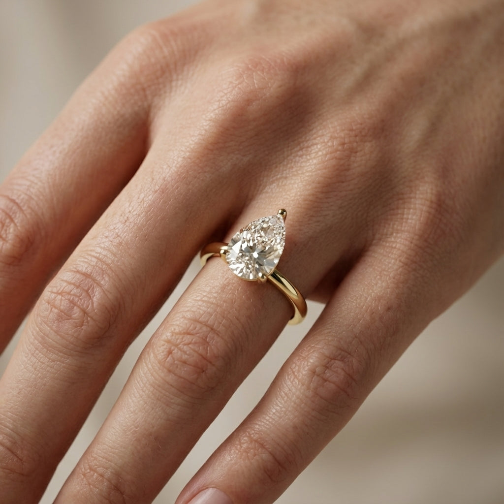 Pear Cut Lab Grown Diamond Solitaire Engagement Ring in Yellow Gold showing traditional band and modern setting.