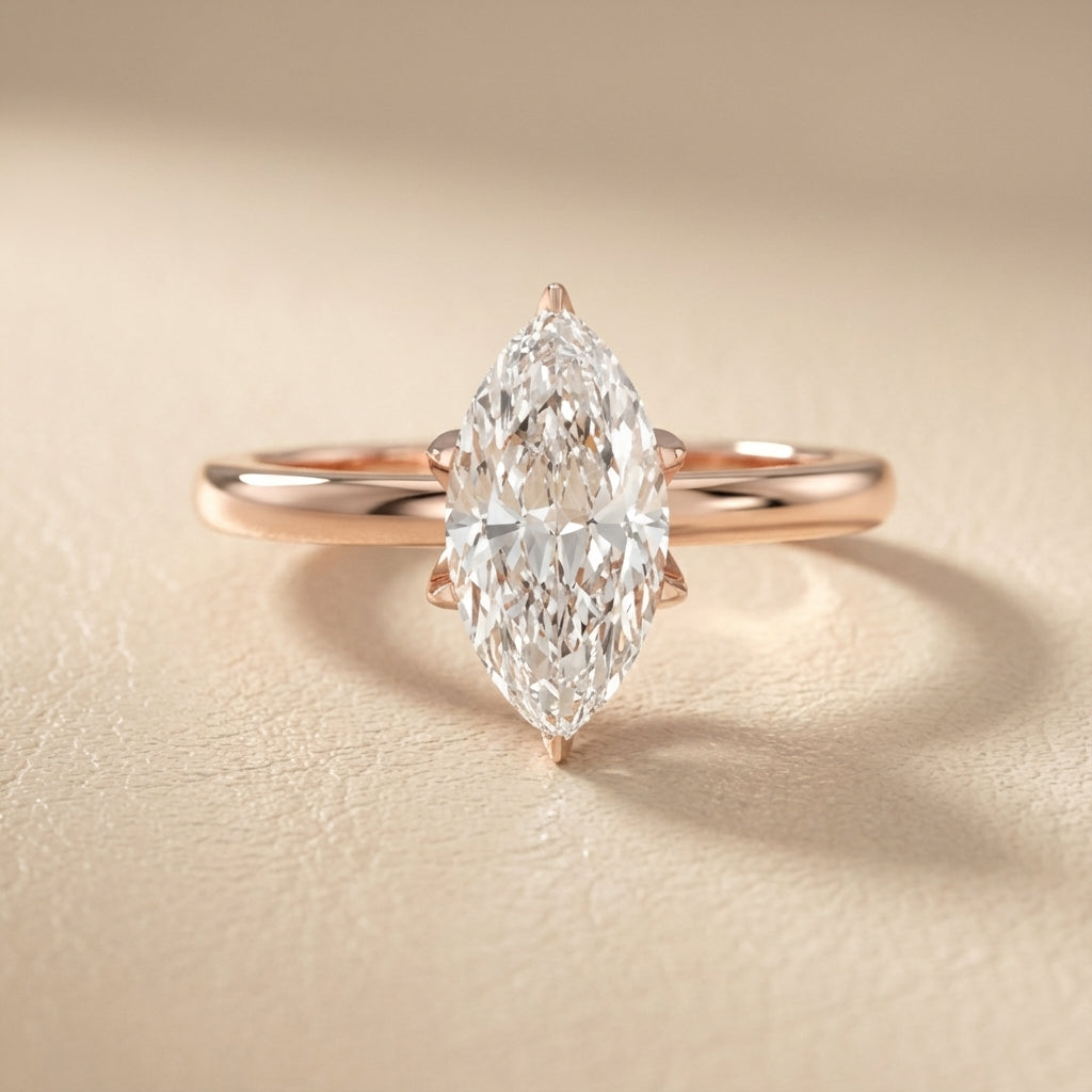 Yellow gold marquise cut lab grown diamond solitaire engagement ring with polished band and floral prongs.