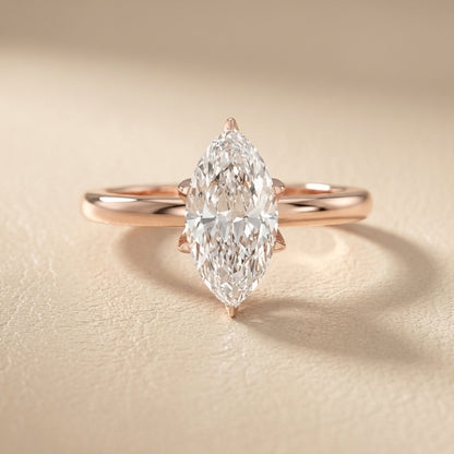 Yellow gold marquise cut lab grown diamond solitaire engagement ring with polished band and floral prongs.