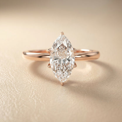 Marquise cut lab grown diamond solitaire engagement ring in rose gold showing cathedral setting and floral prongs.