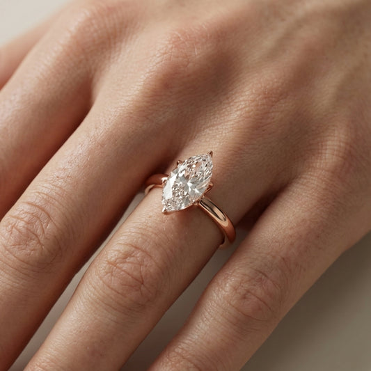 Marquise cut lab grown diamond solitaire engagement ring in rose gold showing cathedral setting and floral prongs.