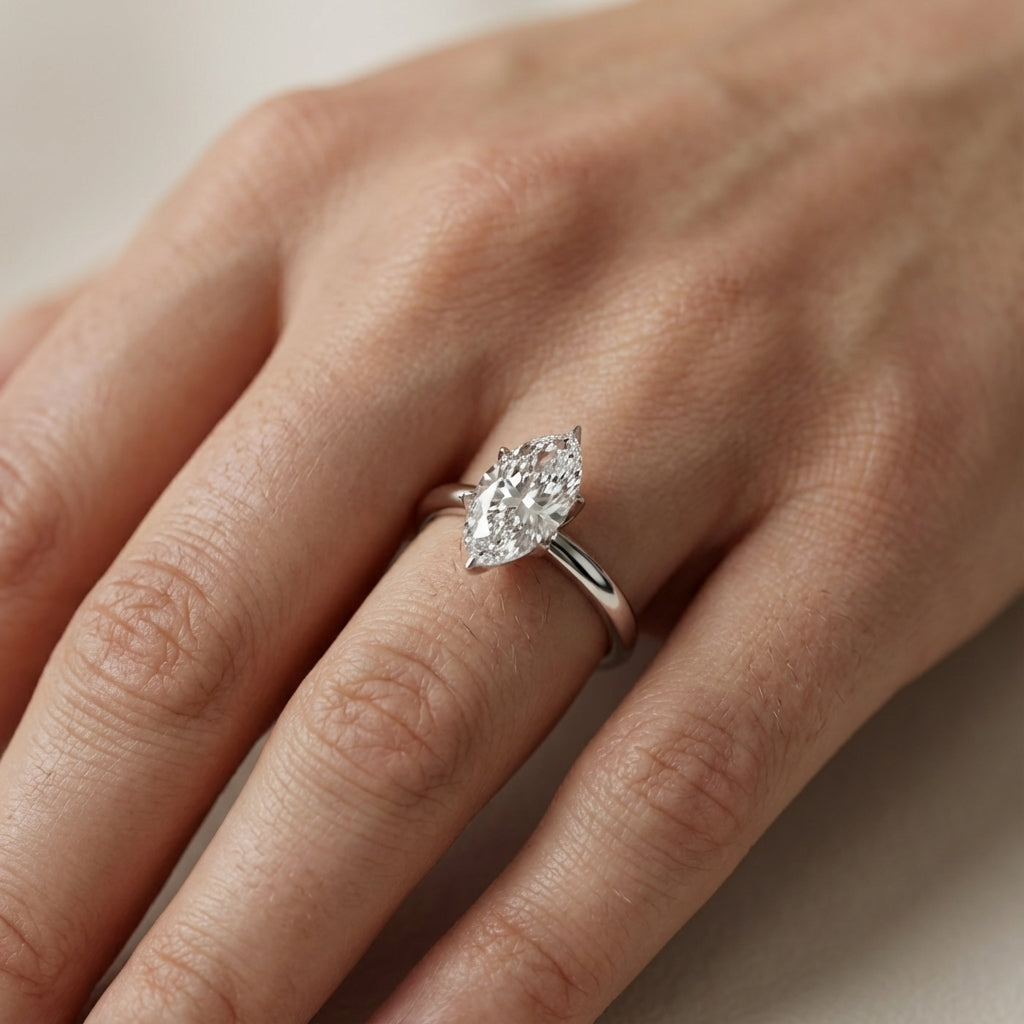 Marquise cut lab grown diamond solitaire engagement ring in silver with floral prong setting.