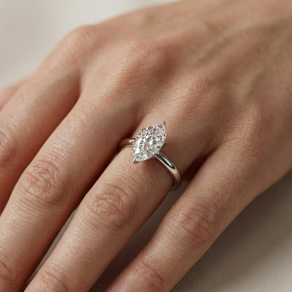 Platinum marquise cut lab grown diamond solitaire engagement ring exhibiting high polish and floral prong details.