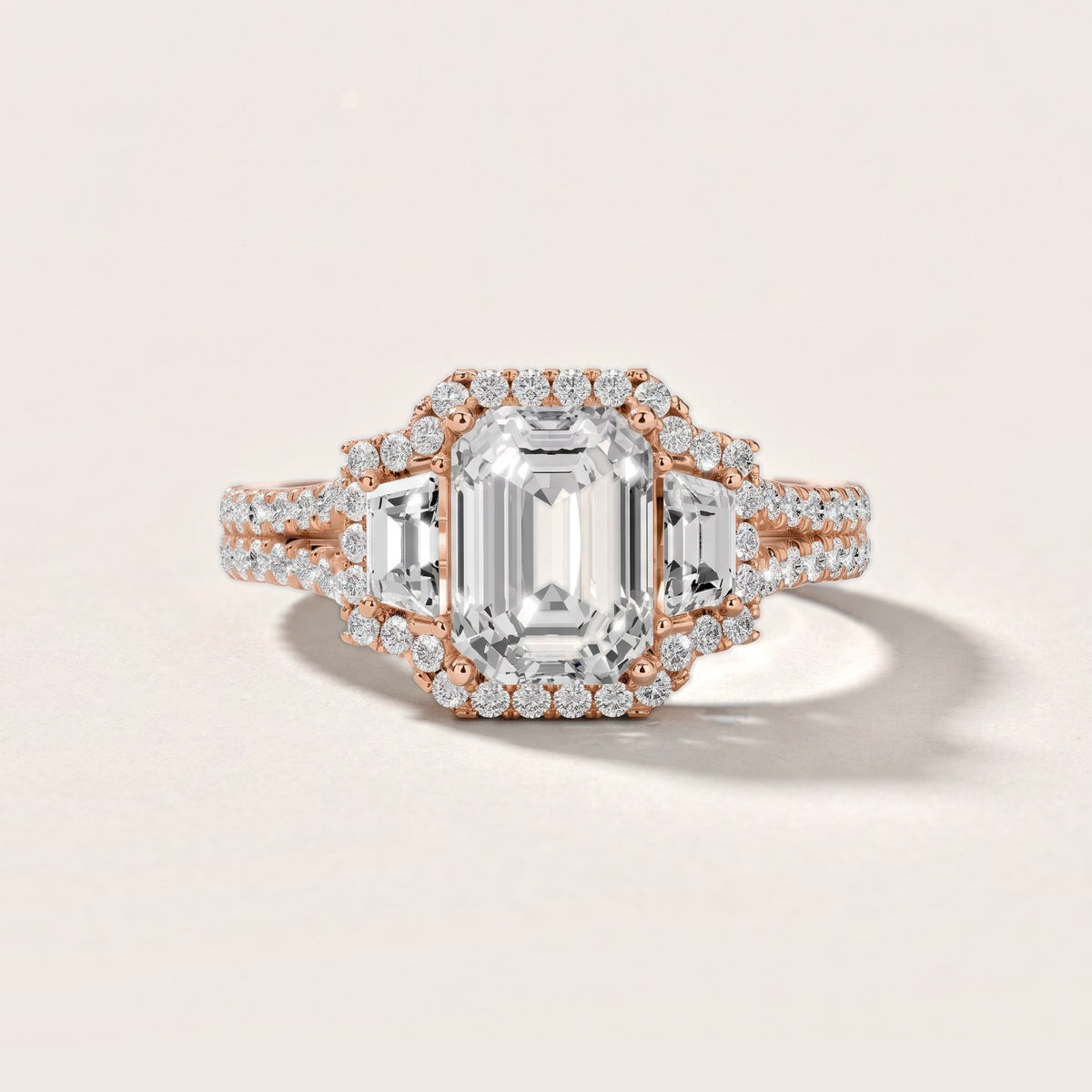 Ronan Three-Stone Halo Emerald Diamond Engagement Ring in Rose Gold - front.jpg