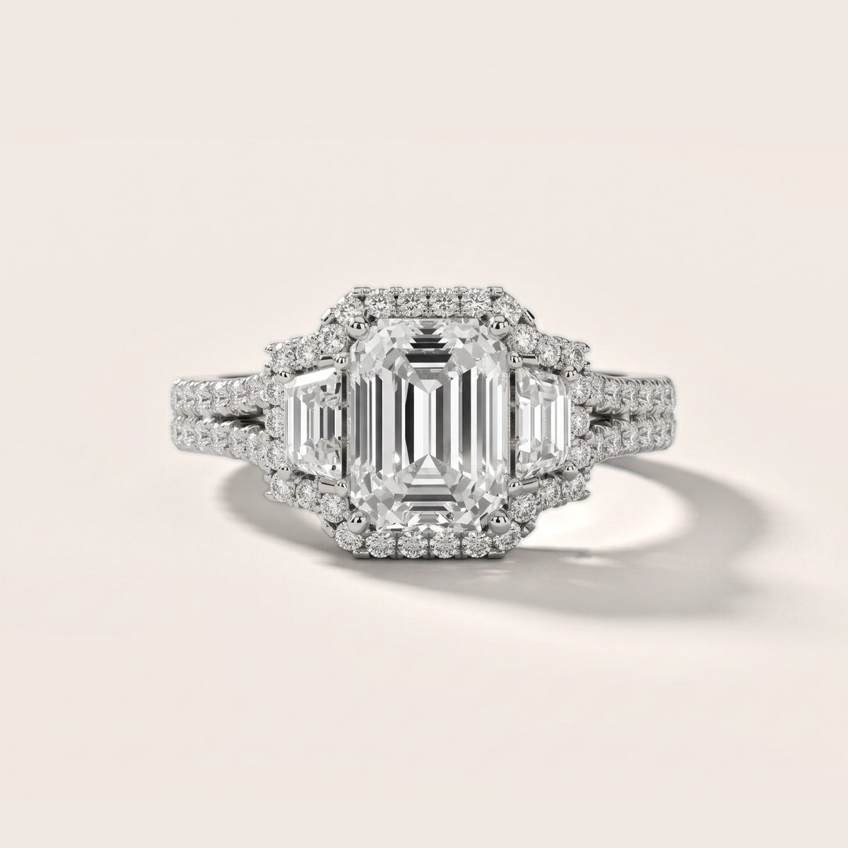 Ronan Three-Stone Halo Emerald Diamond Engagement Ring in Platinum - front.jpg
