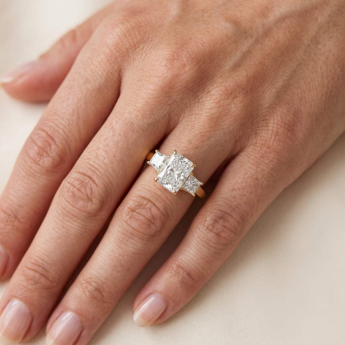 Aria Three-Stone Basket Radiant Diamond Engagement Ring in Yellow Gold - lifestyle.jpg