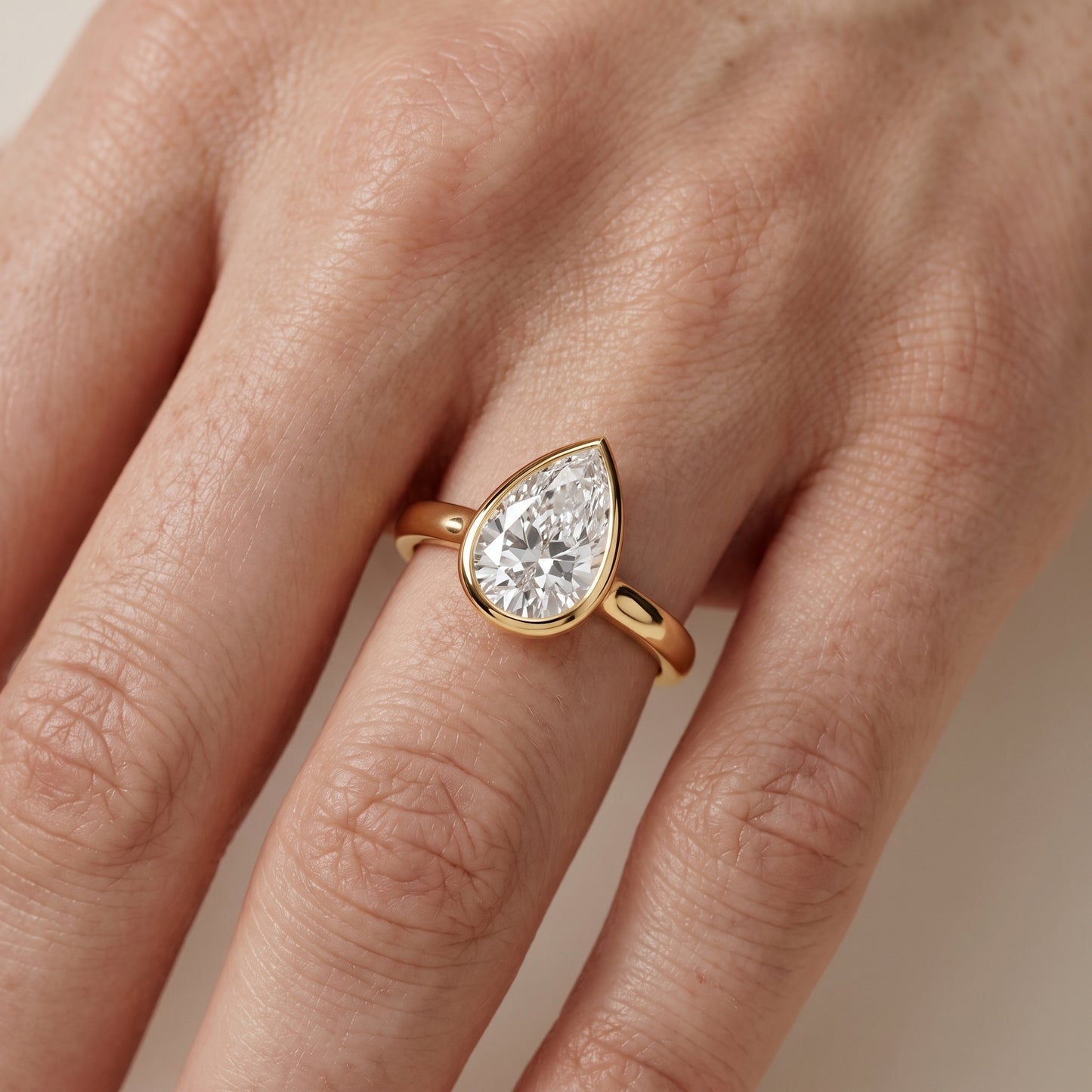 Jolie Bezel Solitaire Pear Diamond Engagement Ring in Yellow Gold - lifestyle.jpg