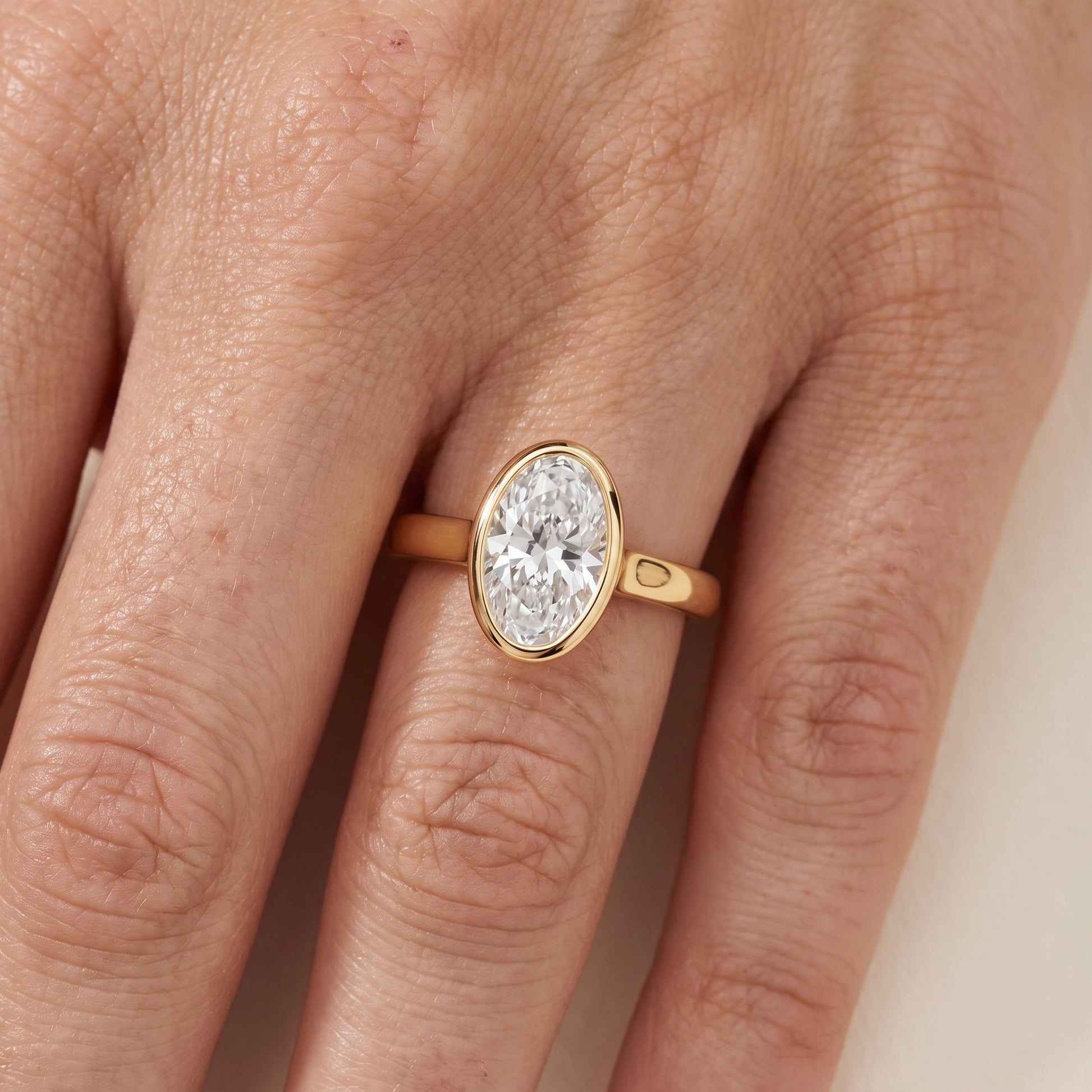 Jolie Bezel Solitaire Oval Diamond Engagement Ring in Yellow Gold - lifestyle.jpg