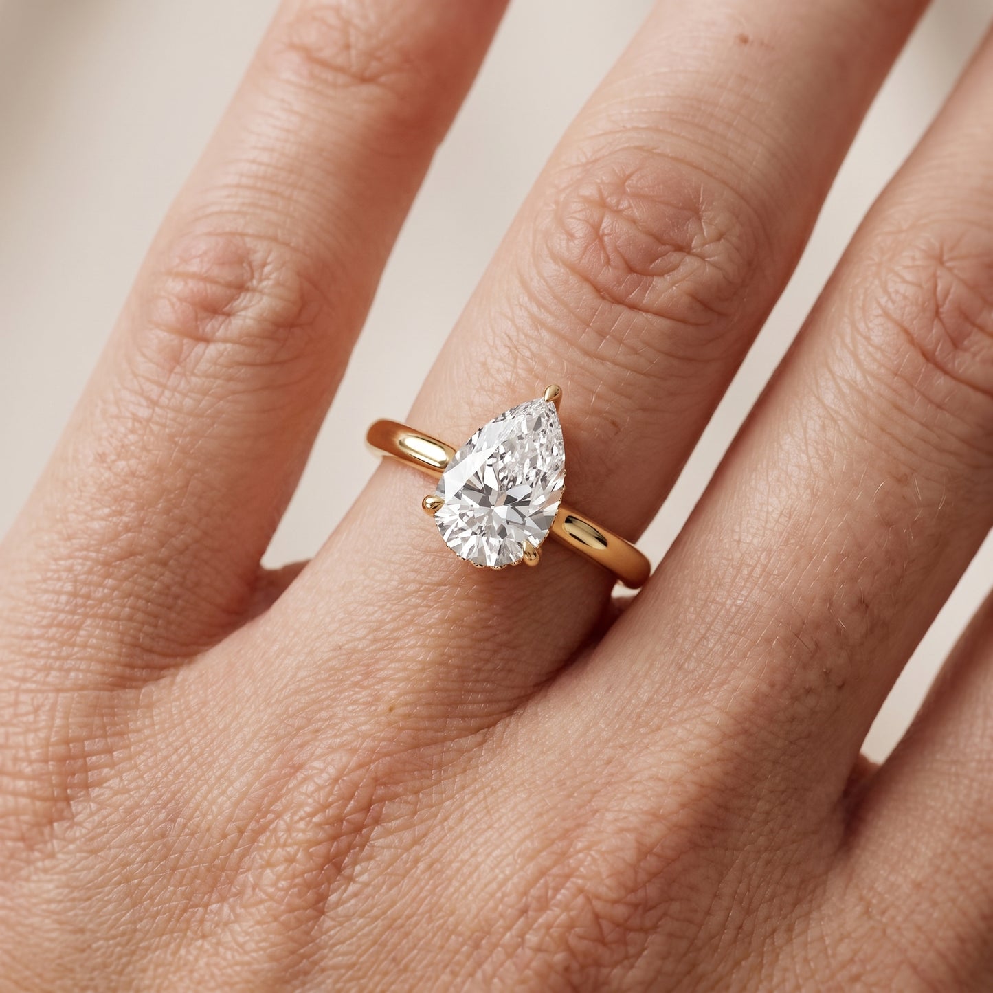 Mena Hidden Halo Pear Diamond Engagement Ring in Yellow Gold - lifestyle.jpg