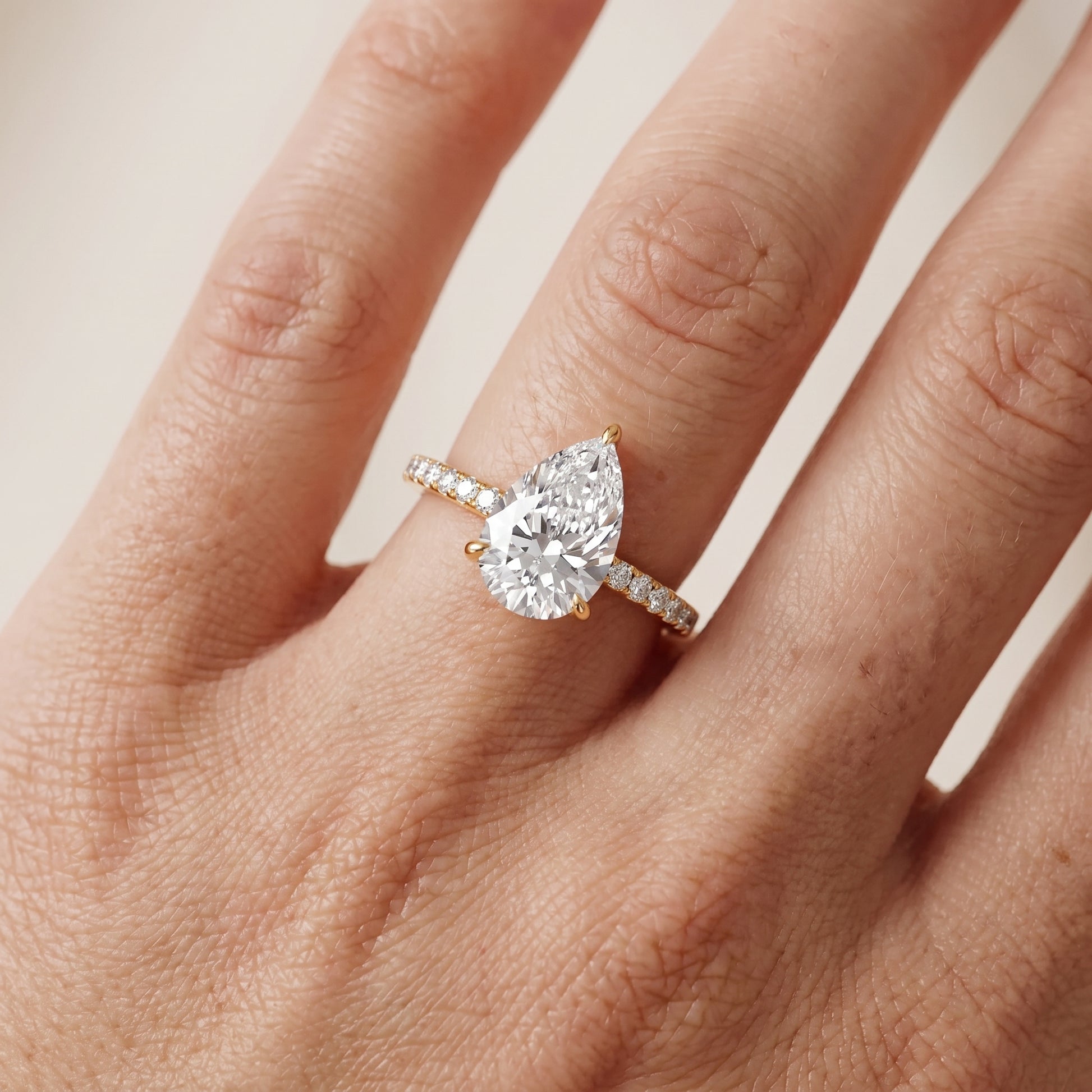 Ione Solitaire Pavé Pear Diamond Engagement Ring in Yellow Gold - lifestyle.jpg