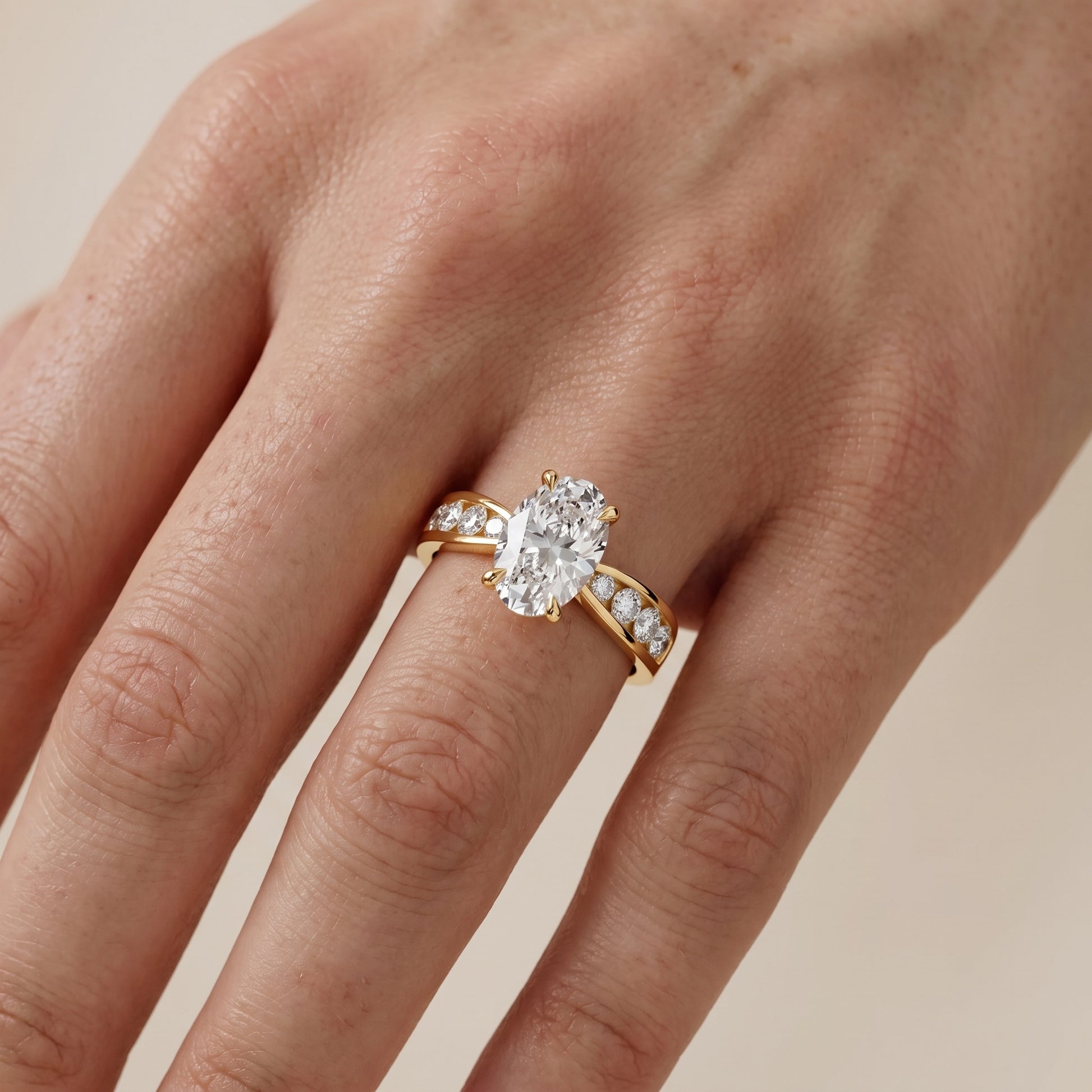 Noor Channel Set Sidestone Oval Diamond Engagement Ring in Yellow Gold - lifestyle.jpg
