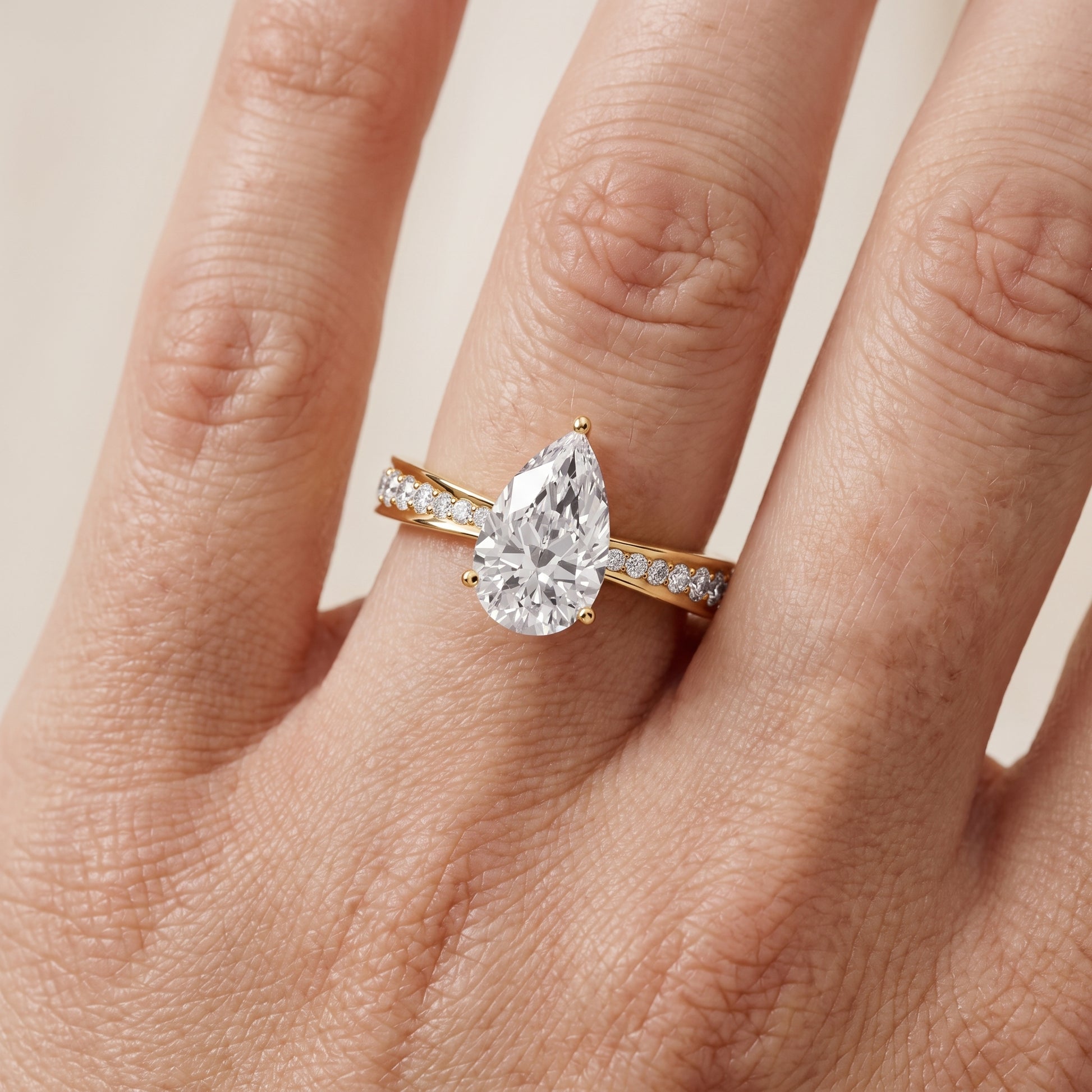 Rhea Sidestone Pavé Pear Diamond Engagement Ring in Yellow Gold - lifestyle.jpg
