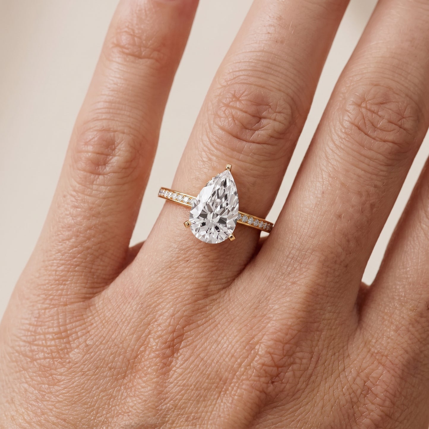 Naia Hidden Halo Pear Diamond Ring in Yellow Gold - lifestyle.jpg