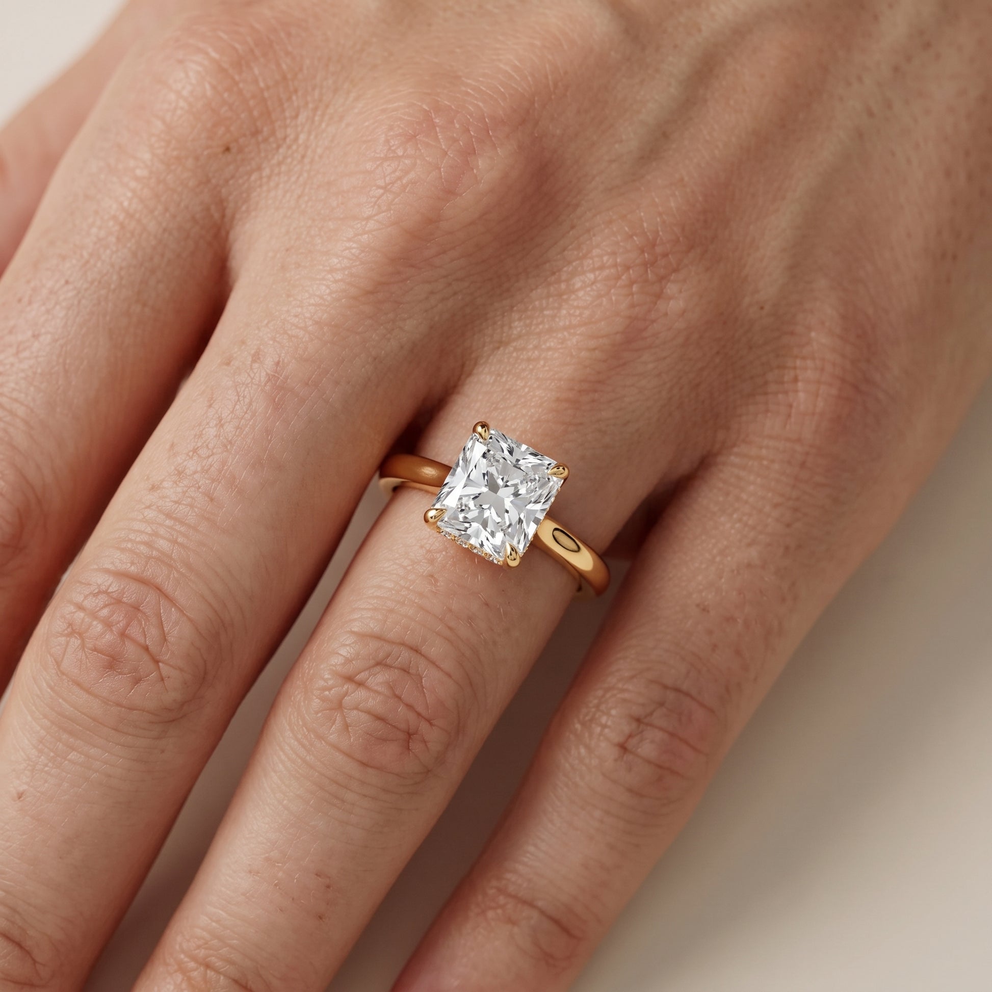 Mena Hidden Halo Radiant Diamond Engagement Ring in Yellow Gold - lifestyle.jpg