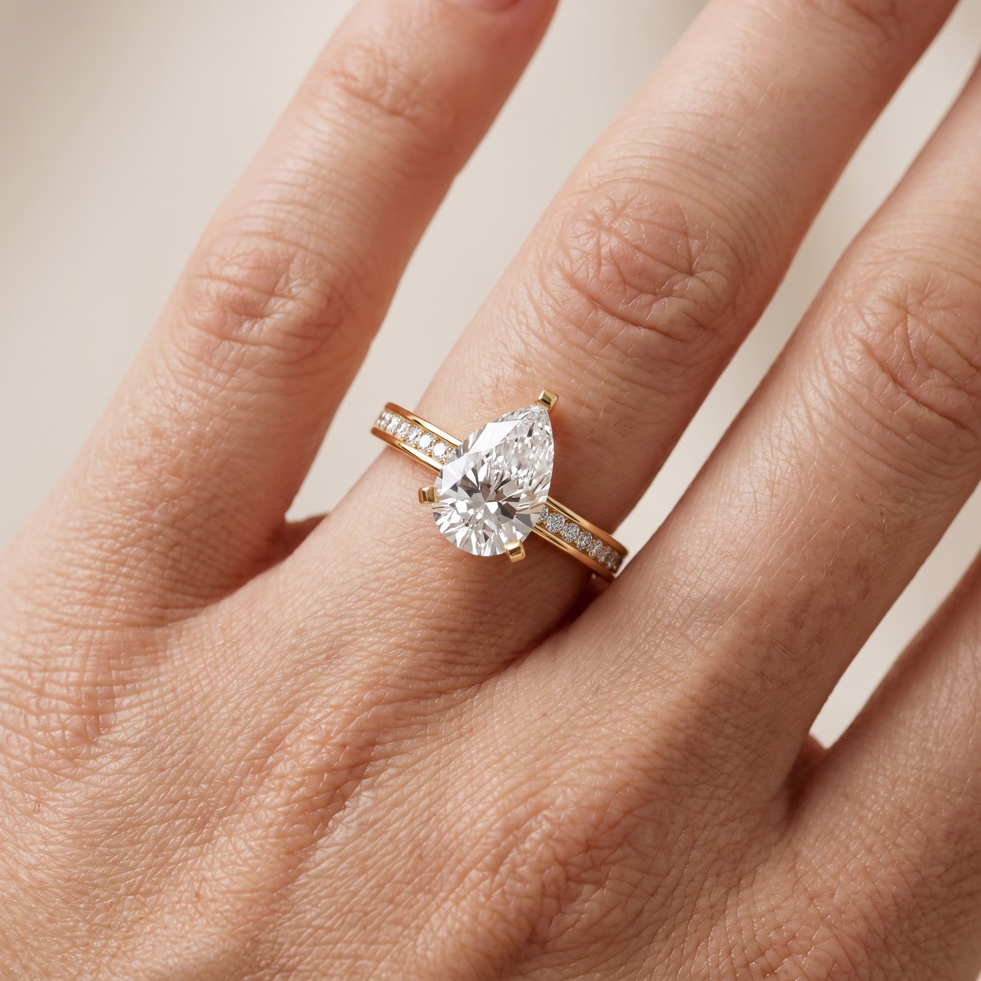 Tessa Solitaire Channel Set Pear Diamond Engagement Ring in Yellow Gold - lifestyle.jpg