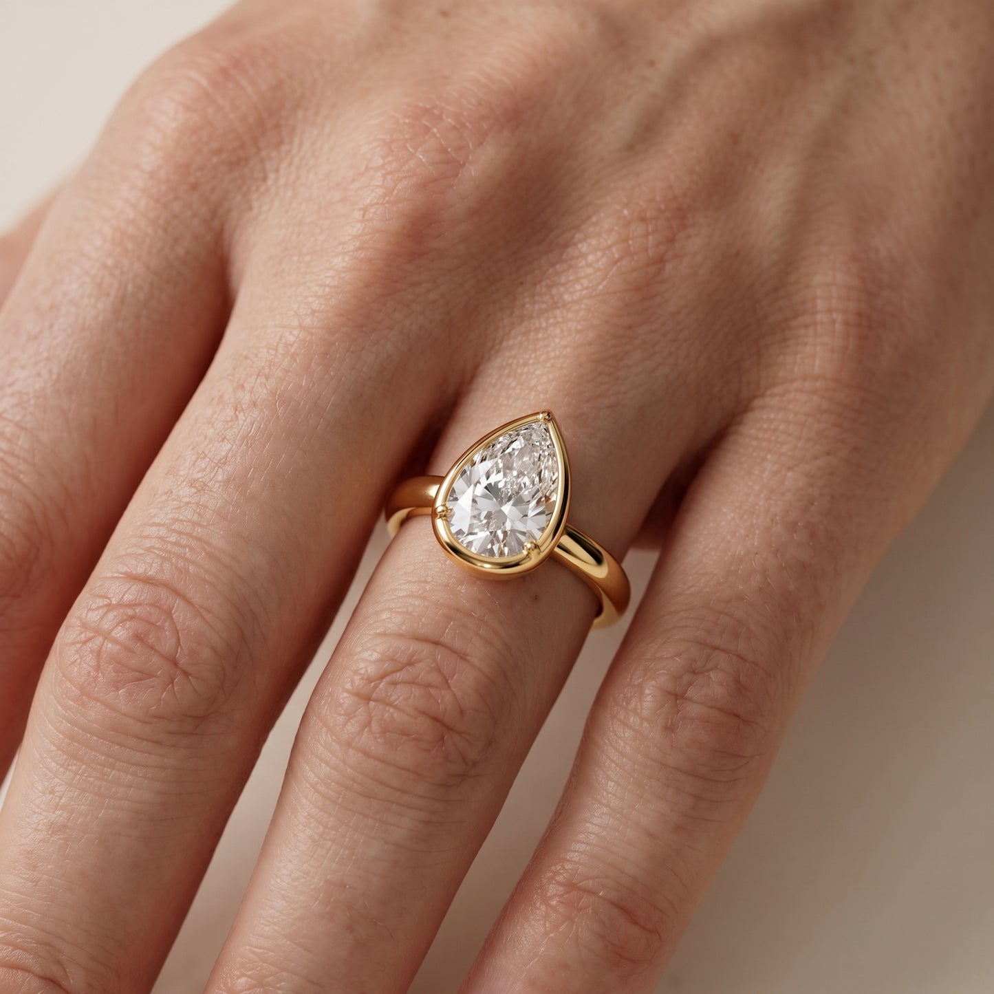 Alina Bezel Solitaire Pear Diamond Ring in Yellow Gold - lifestyle.jpg