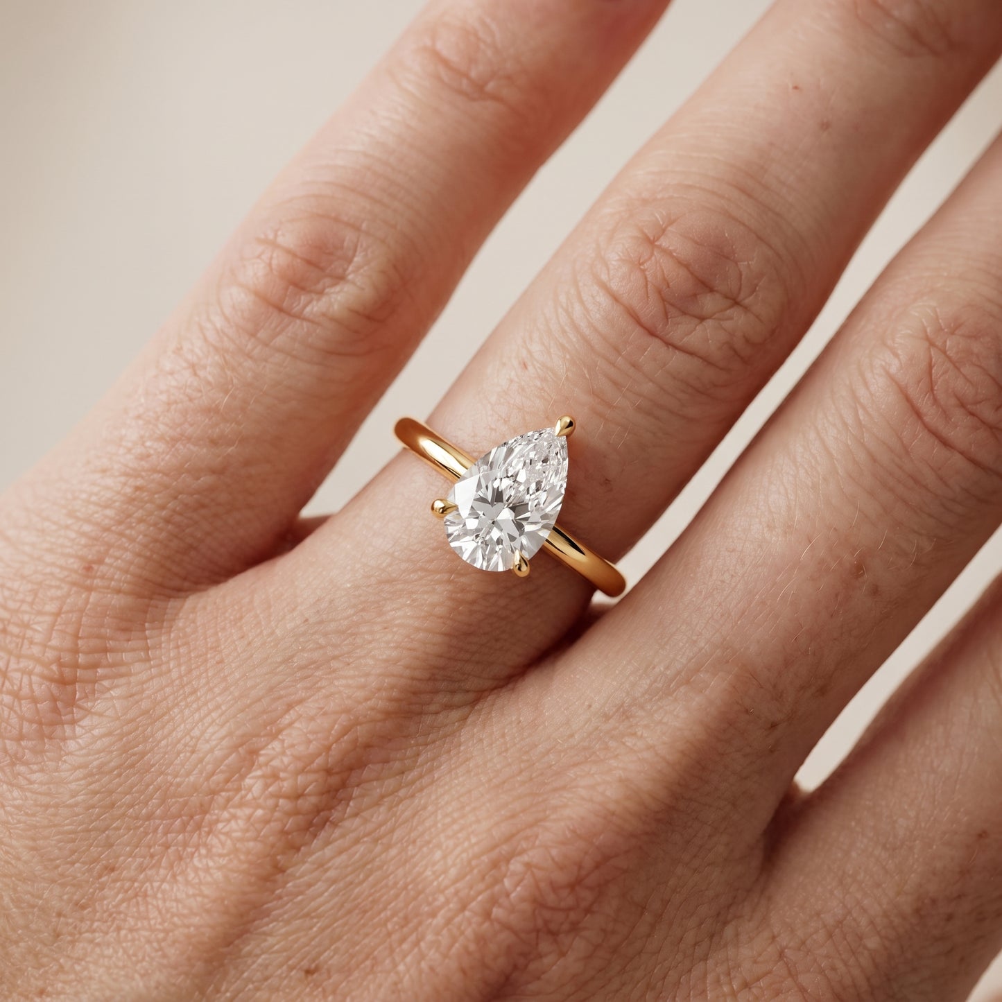 Nella Petite Solitaire Pear Diamond Engagement Ring in Yellow Gold - lifestyle.jpg