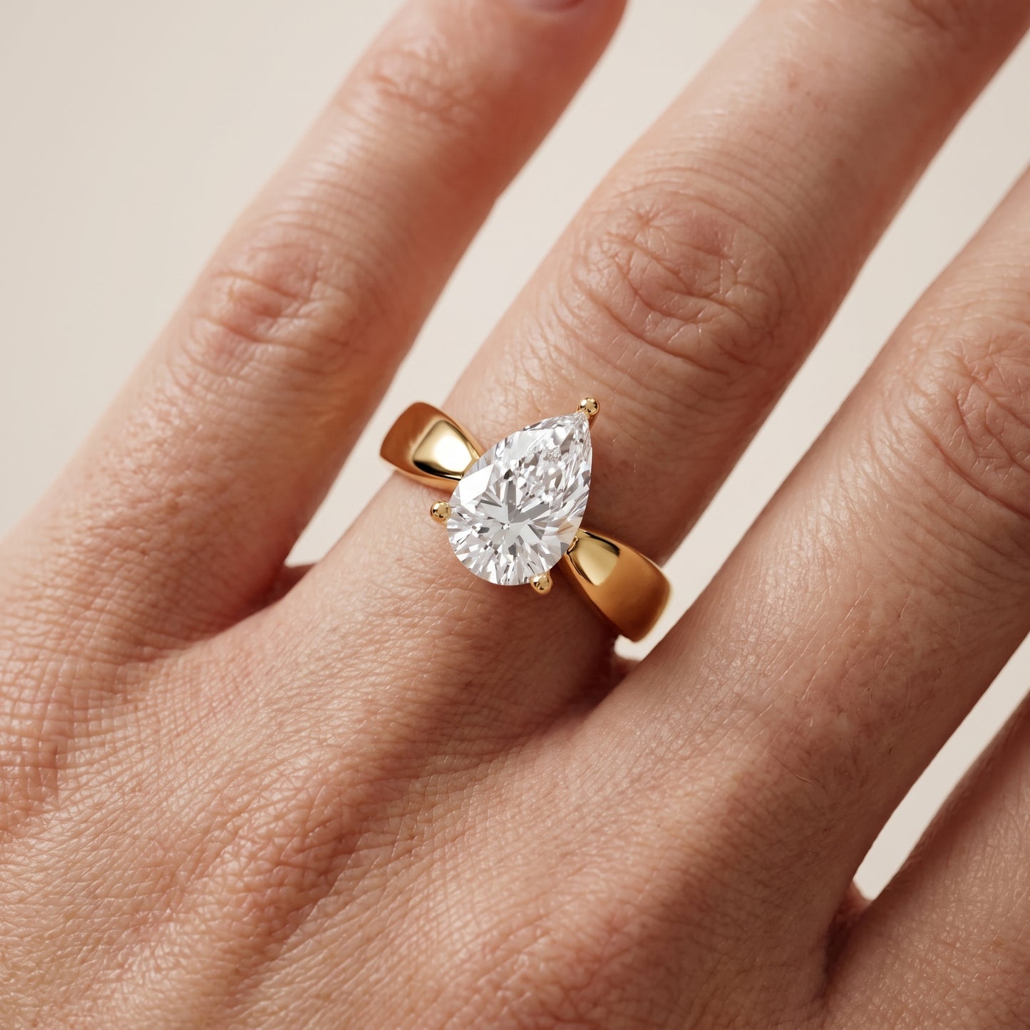 Talia Solitaire Twist Pear Diamond Engagement Ring in Yellow Gold - lifestyle.jpg