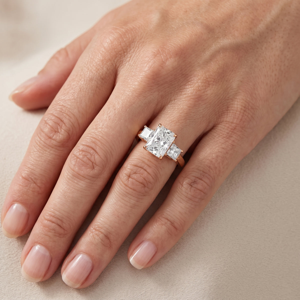 Aria Three-Stone Basket Radiant Diamond Engagement Ring in Rose Gold - lifestyle.jpg