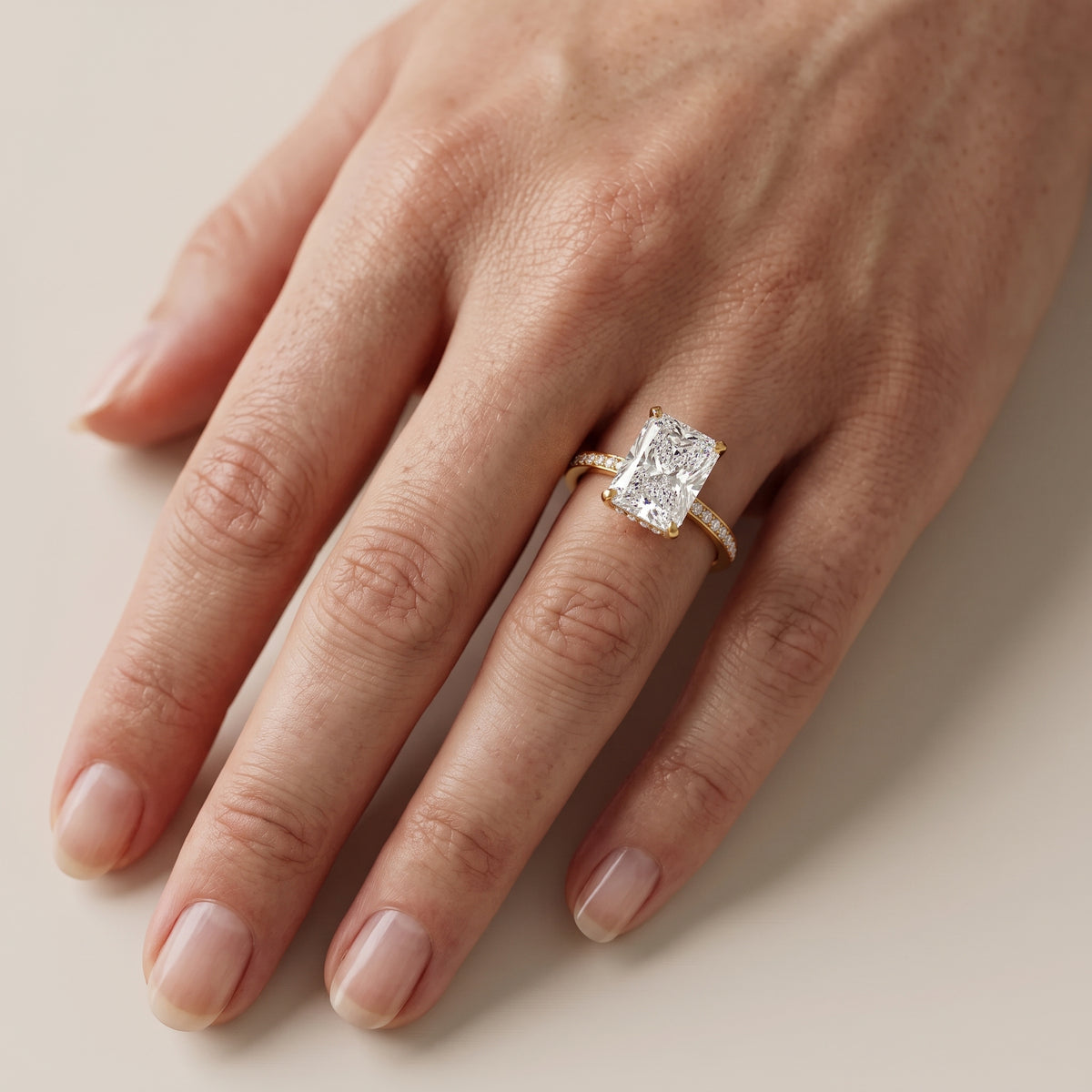 Naia Hidden Halo Radiant Diamond Engagement Ring in Yellow Gold - lifestyle.jpg
