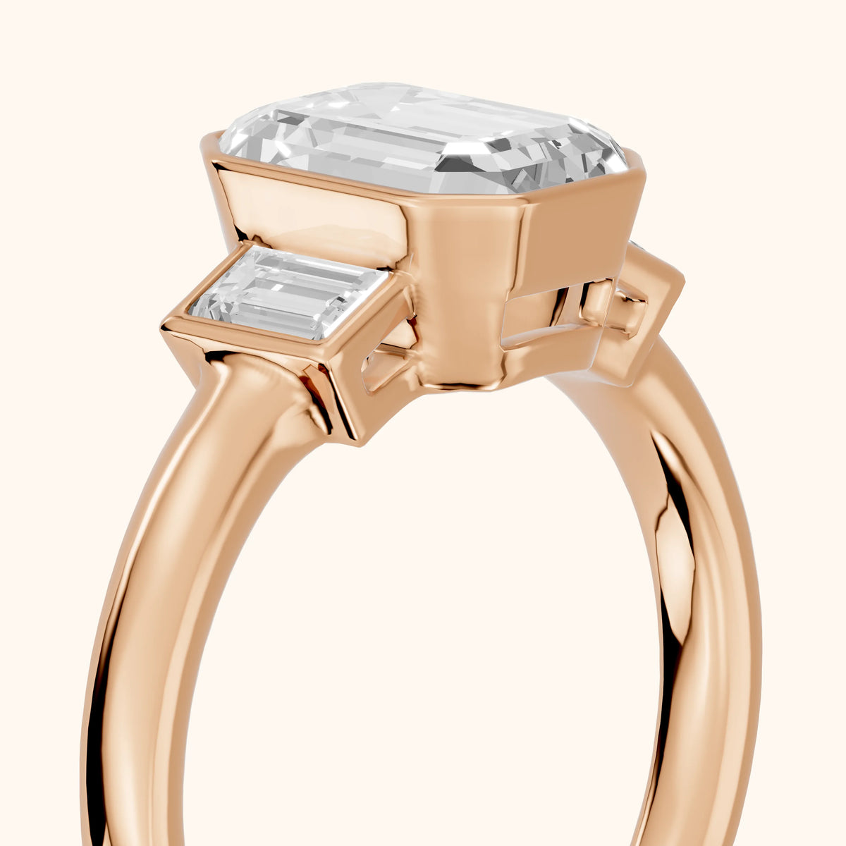 Paia Bezel Three-Stone Emerald Diamond Engagement Ring in Rose Gold - slant-view.webp