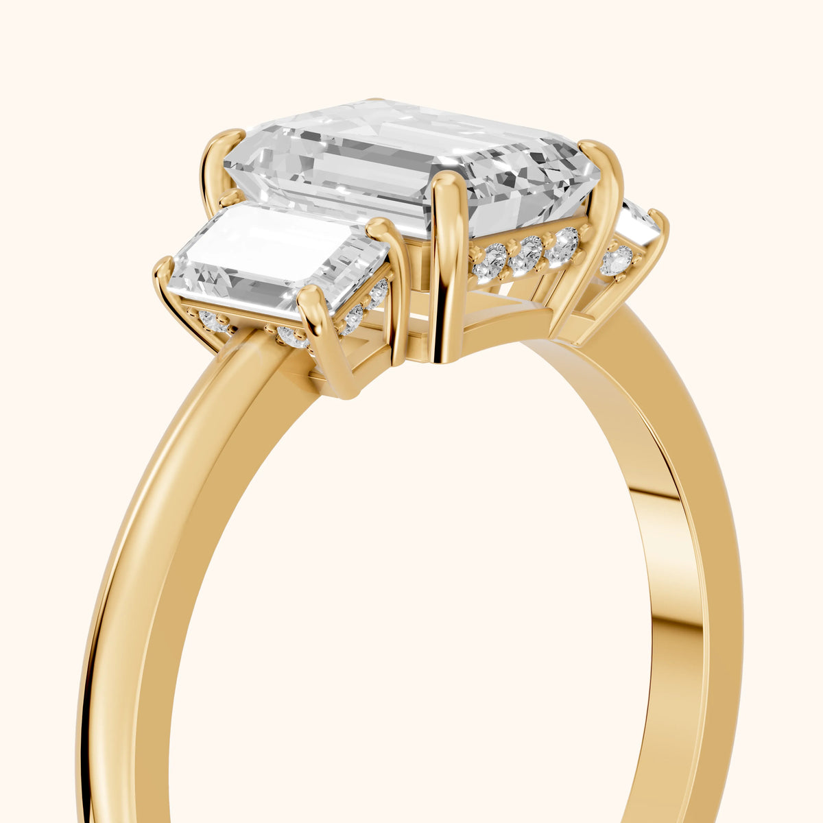 Marian Three-Stone Hidden Halo Emerald Diamond Engagement Ring in Yellow Gold - slant-view.webp