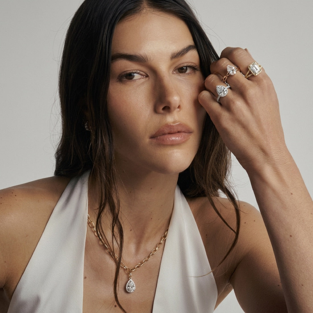 Woman wearing lab grown diamond engagement rings and a pear pendant